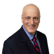 Professional headshot of a man with dark blazer, light blue shirt and red striped tie